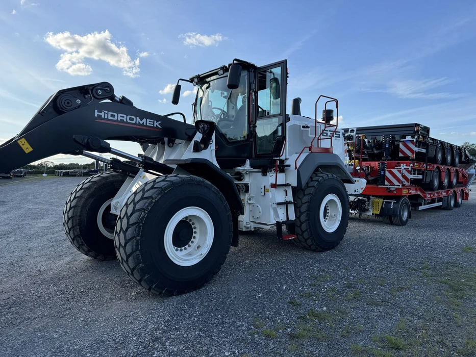 Scène extérieure sur terrain industriel avec ciel bleu nuageux