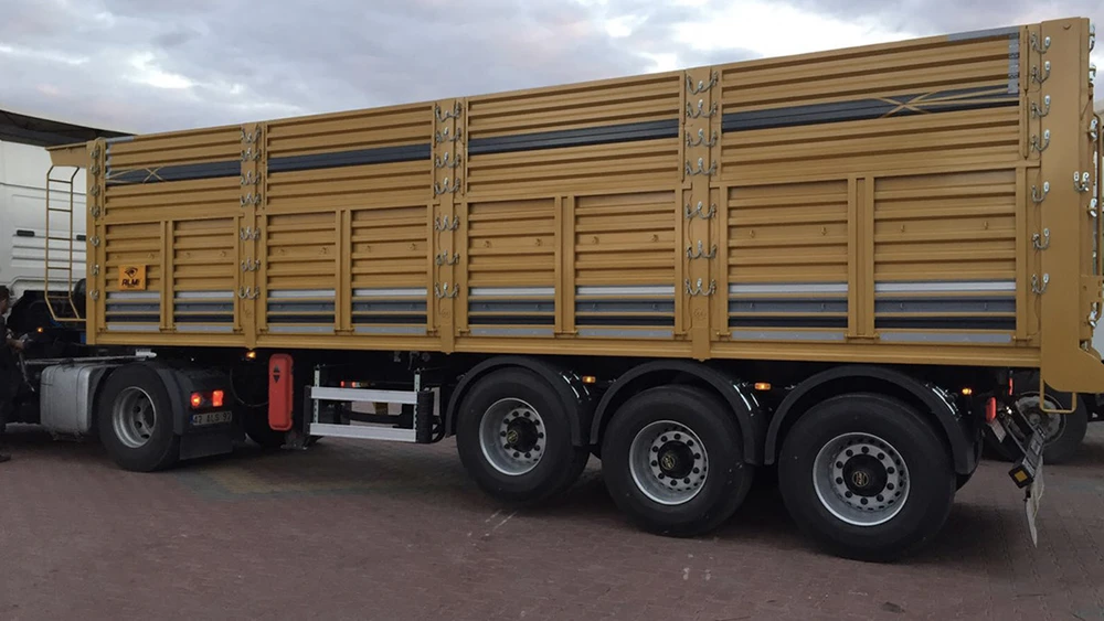 Scène extérieure d'un camion semi-remorque stationné sur terrain industriel sous ciel nuageux