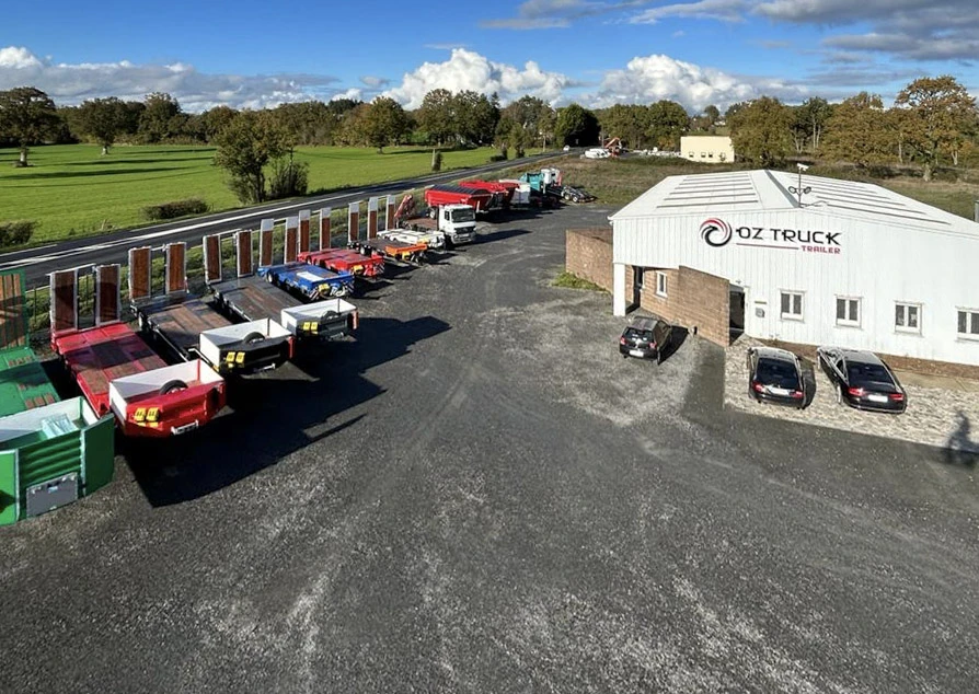 Chantier de construction extérieur avec ouvrier en vêtements de sécurité haute visibilité tenant un casque de protection jaune