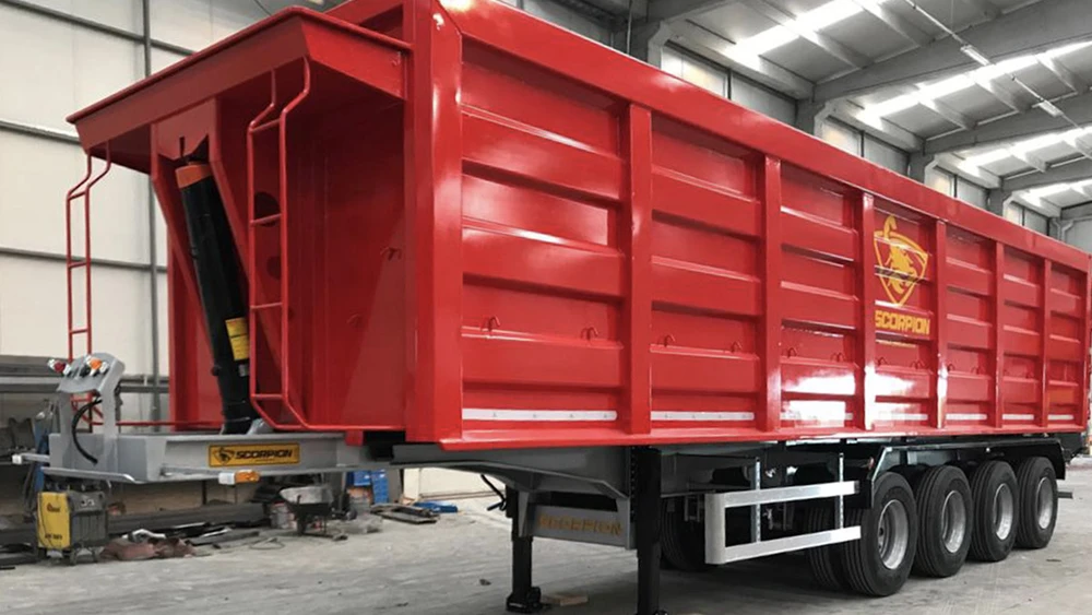 Scène extérieure d'un chantier avec chargeuse compacte Kramer stationnée devant hangar métallique ouvert