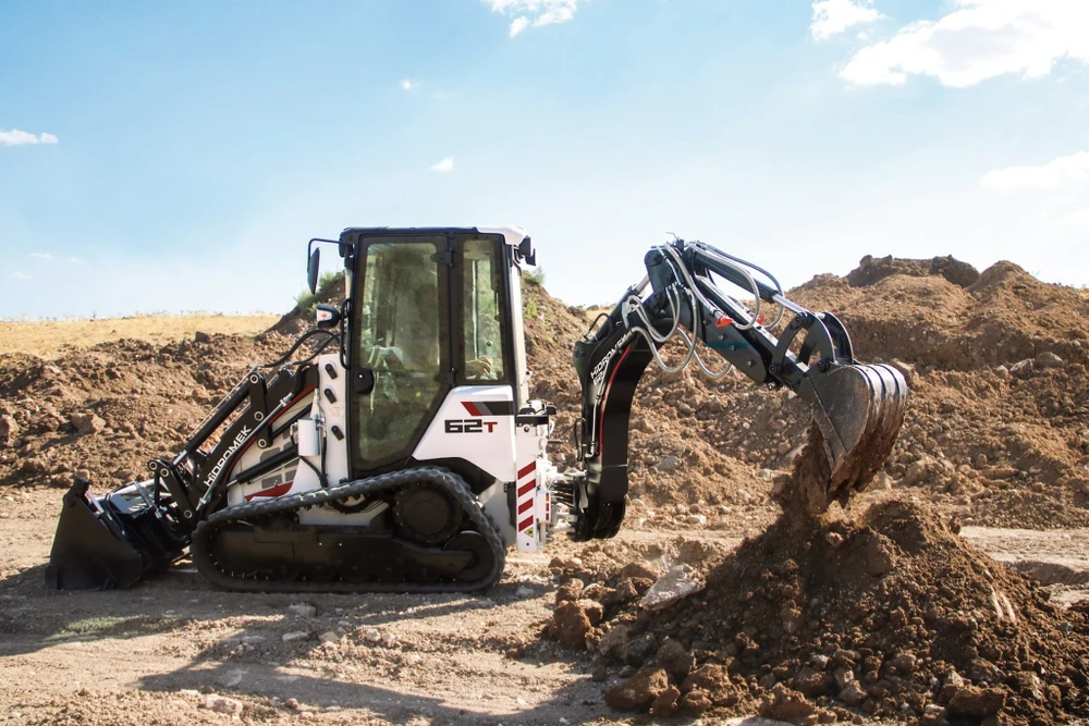 Scène extérieure d'un site industriel avec semi-remorque porte-engins Scorpion stationnée sur dalle béton
