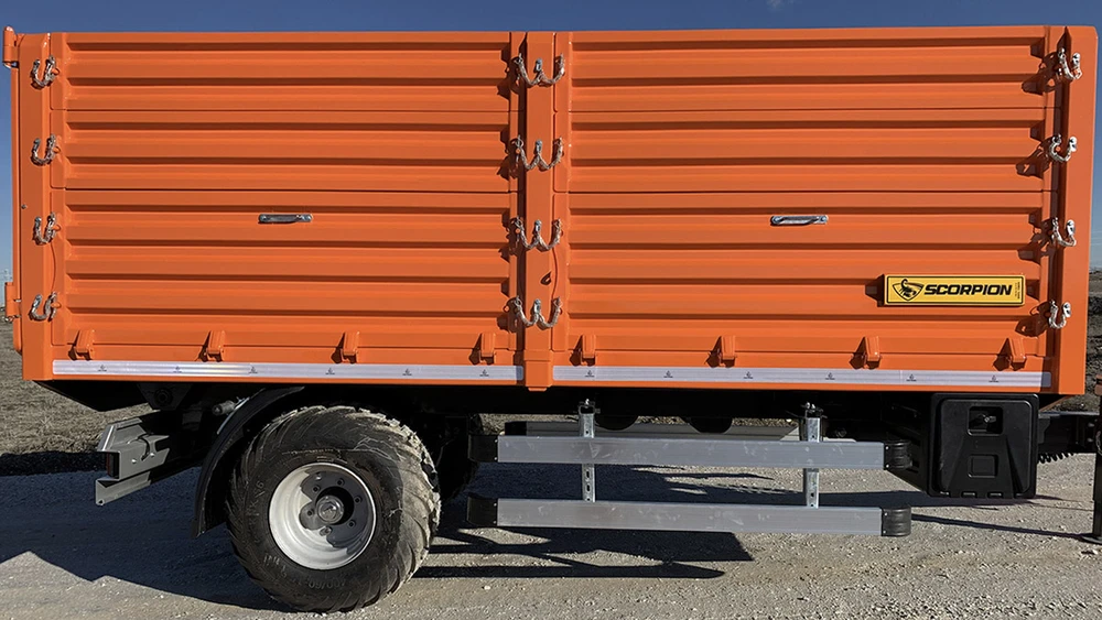 Camion semi-remorque avec plateau surbaissé rouge stationné devant bâtiment industriel moderne